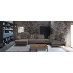 Καφέ γωνιακός καναπές “Roche” τοποθετημένος σε industrial boho loft: πέτρινοι τοίχοι, γκρι μοκέτα και ράφι βιβλιοθήκης. (Thumb 8)